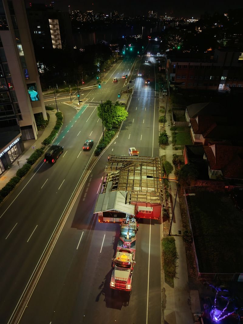 Aerial view of a house moving through city streets at night